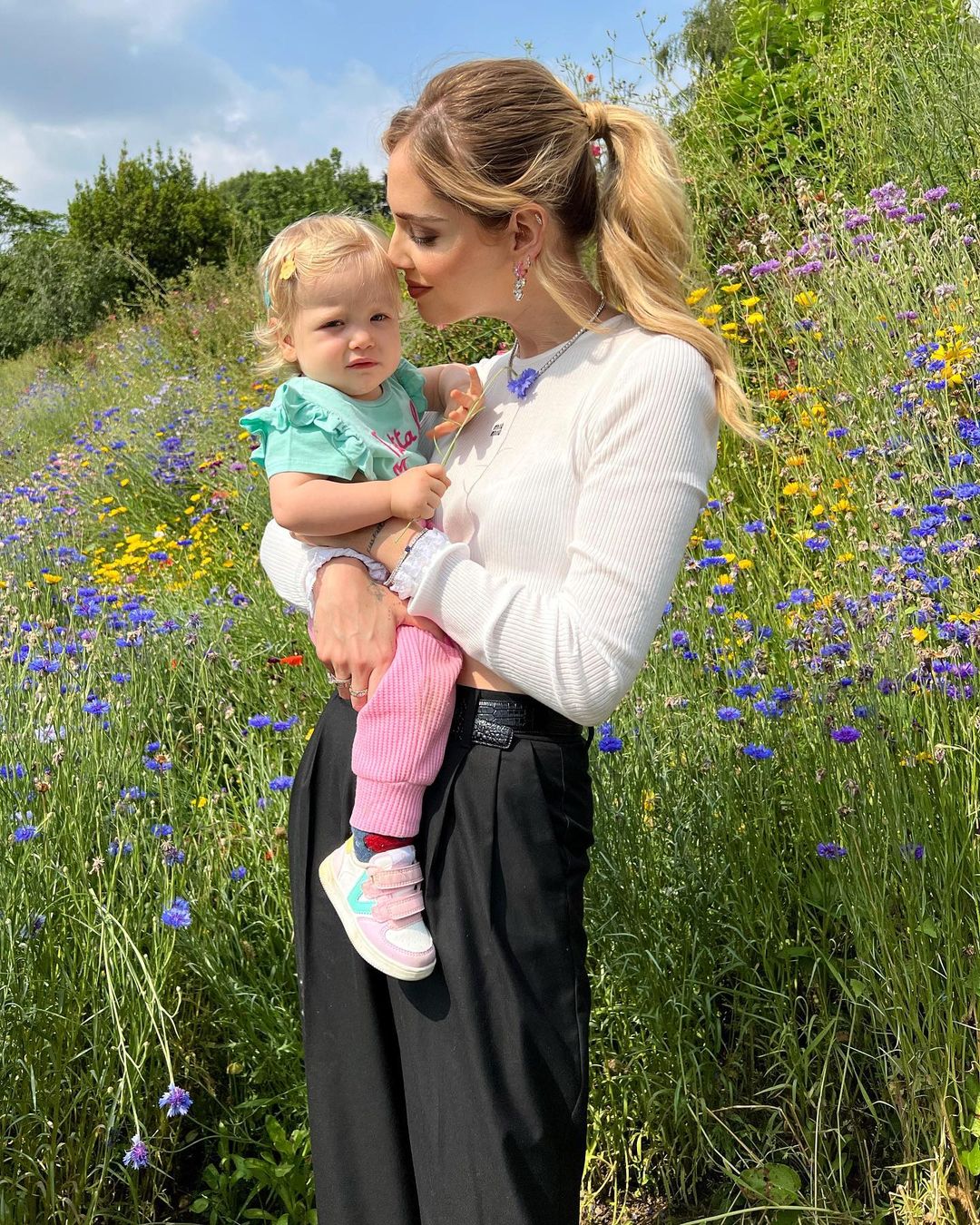 Chiara Ferragni con su hija en brazos en un campo de flores