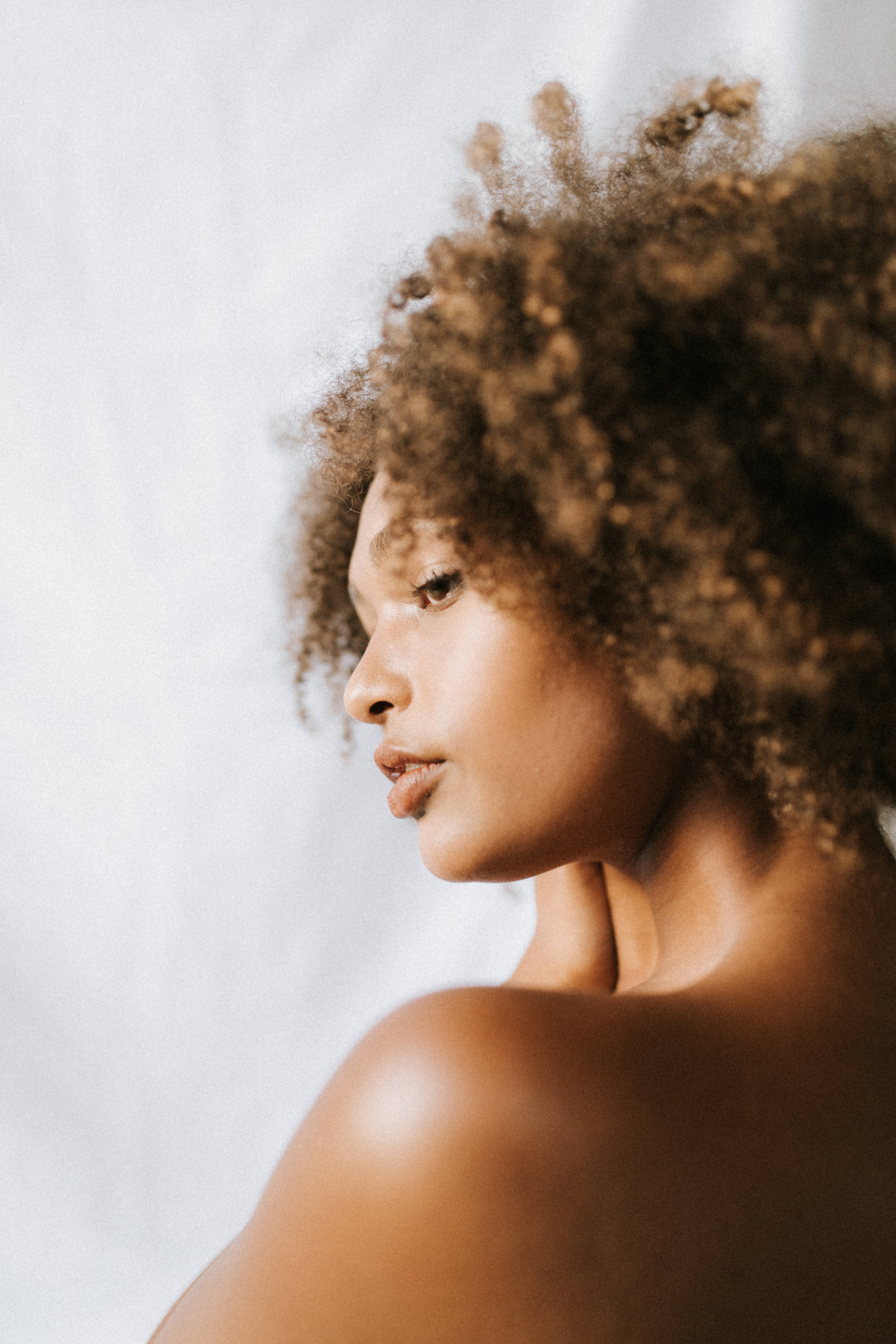Mujer afroamericana de perfil con el pelo afro castaño