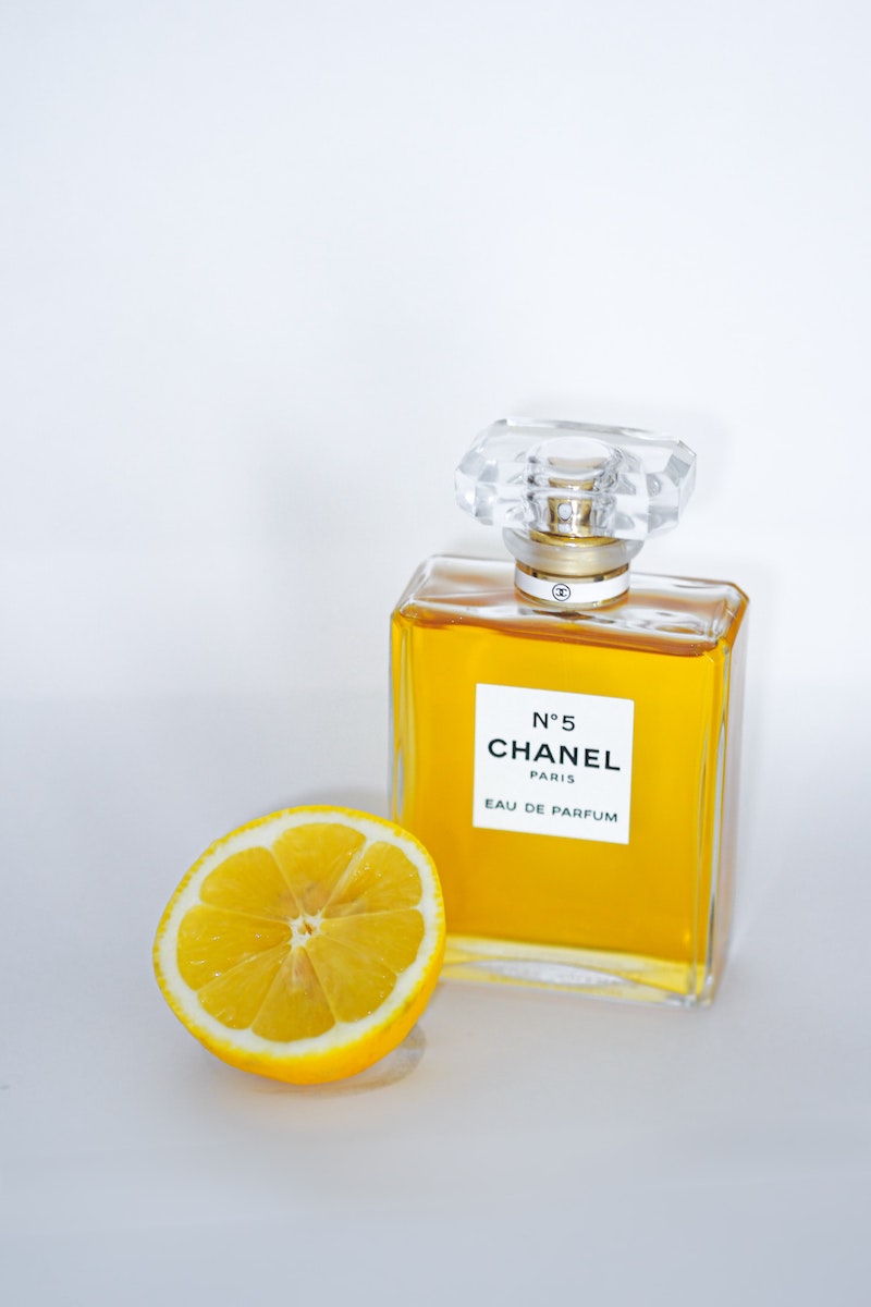 Imagen del perfume Chanel Nº5 con medio limón sobre fondo blanco