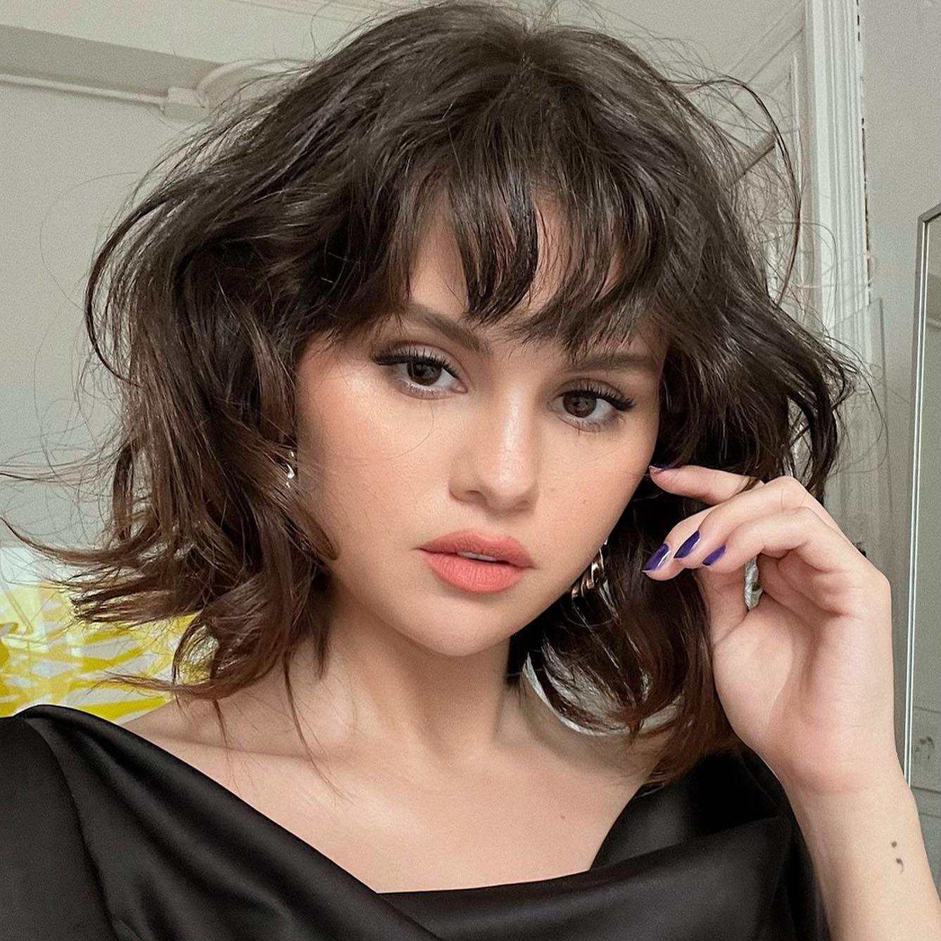 La actriz Selena Gómez posa con un corte de pelo bob ondulado y flequillo despuntado con un maquillaje natural