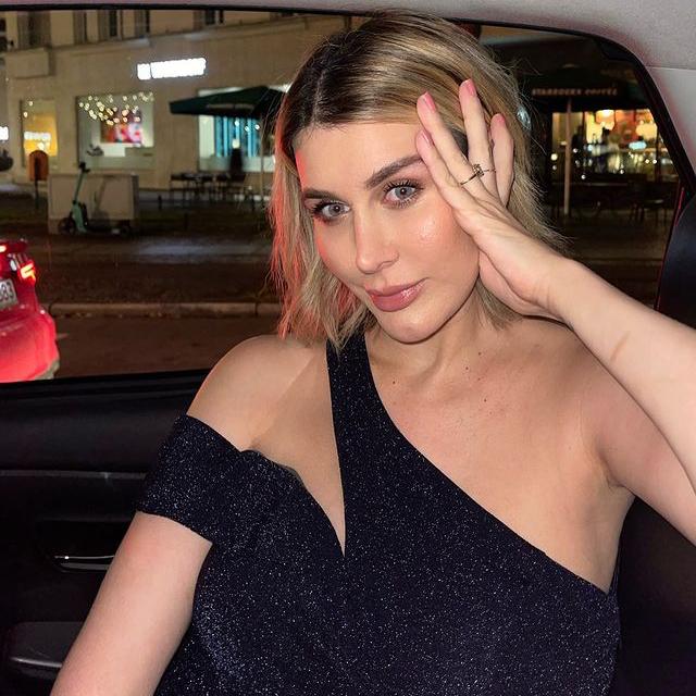 La influencer Victoria Tori Scheu con un vestido cut out posa en un coche con un maquillaje natural