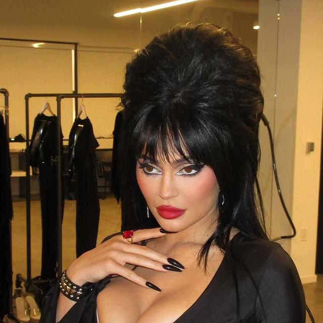 Kylie Jenner con un maquillaje con un maxi eyeliner, labios rojos y uñas en color negro