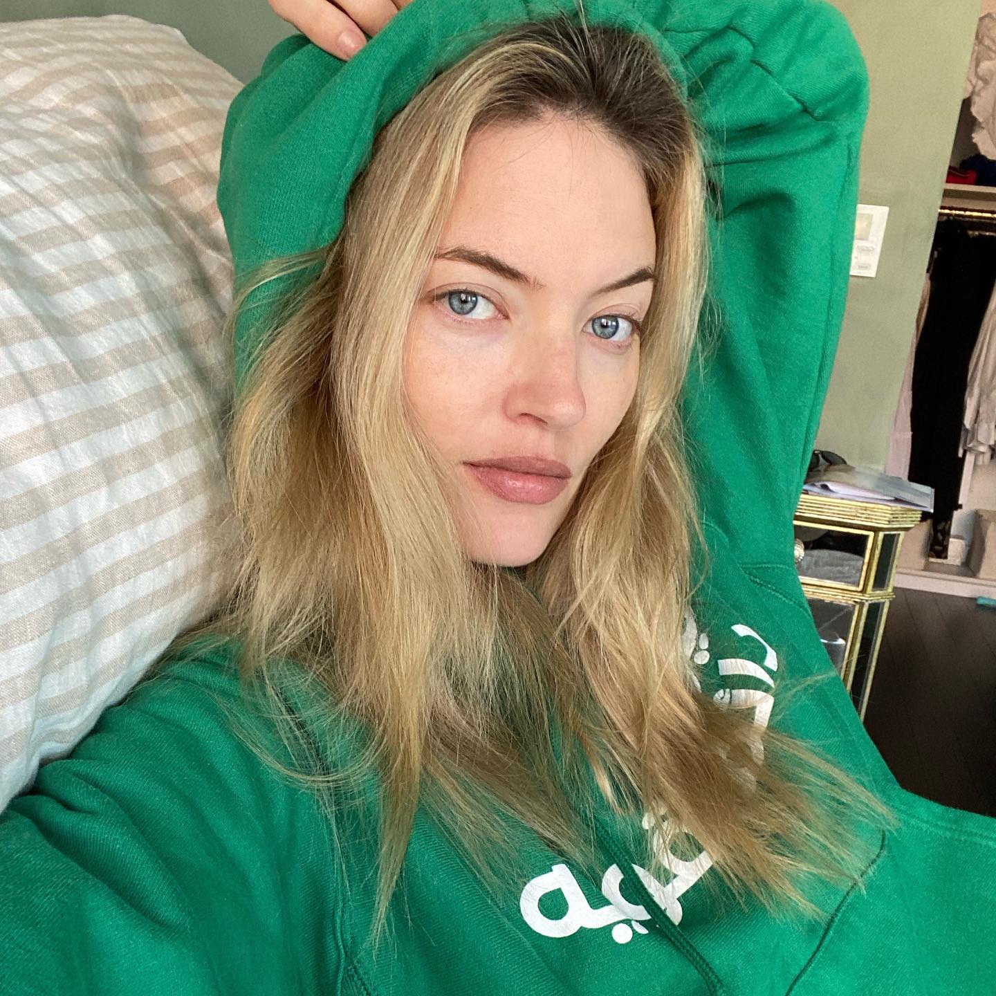 La modelo Martha Hunt posa en un selfie sin maquillaje y el pelo suelto con una sudadera verde